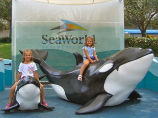 Girls posing with Shamu statues
